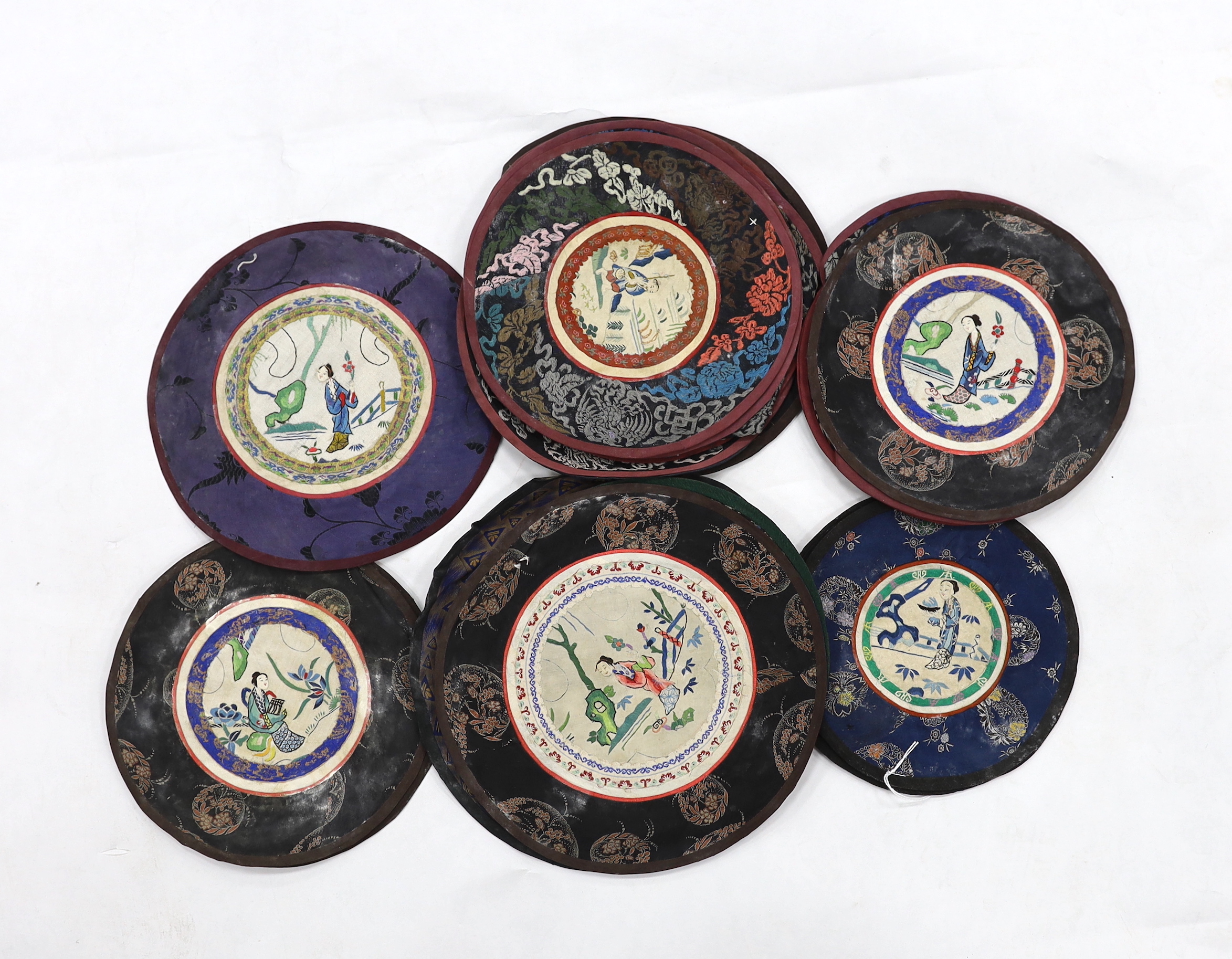 Thirty assorted Chinese silk circular mats, all embroidered with figures, all bordered with silk damask